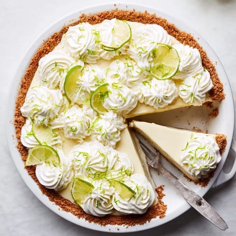 Freshly baked Key Lime Pie with a golden graham cracker crust, filled with bright green custard and crowned with fluffy whipped cream. 