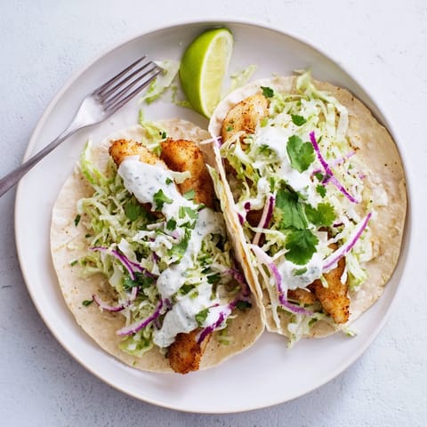 Succulent grilled fish tacos garnished with fresh cilantro and lime wedges, served on a wooden board for a coastal vibe.
