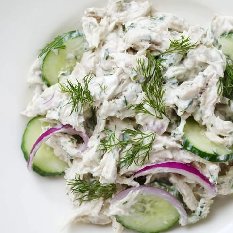 Vibrant creamy cucumber chicken salad topped with chopped green onions, served chilled and ready for a refreshing summer lunch.
