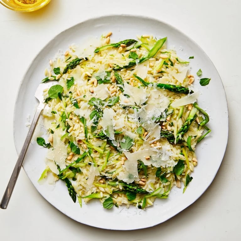 A vibrant bowl of Asparagus Lemon Orzo Salad with fresh herbs and lemon zest, ready for a spring picnic.