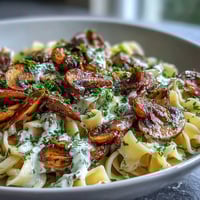 Creamy Mushroom Stroganoff served over fettuccine, garnished with fresh parsley and cracked black pepper.